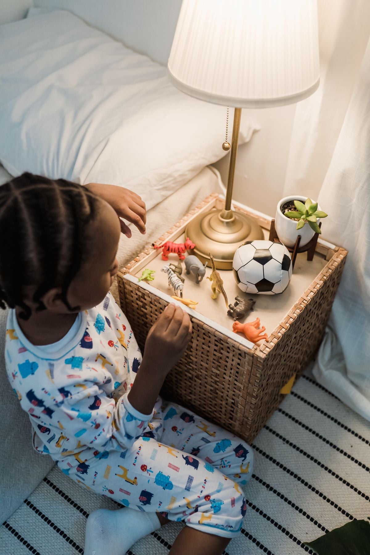 Child playing with a few toys on the bed