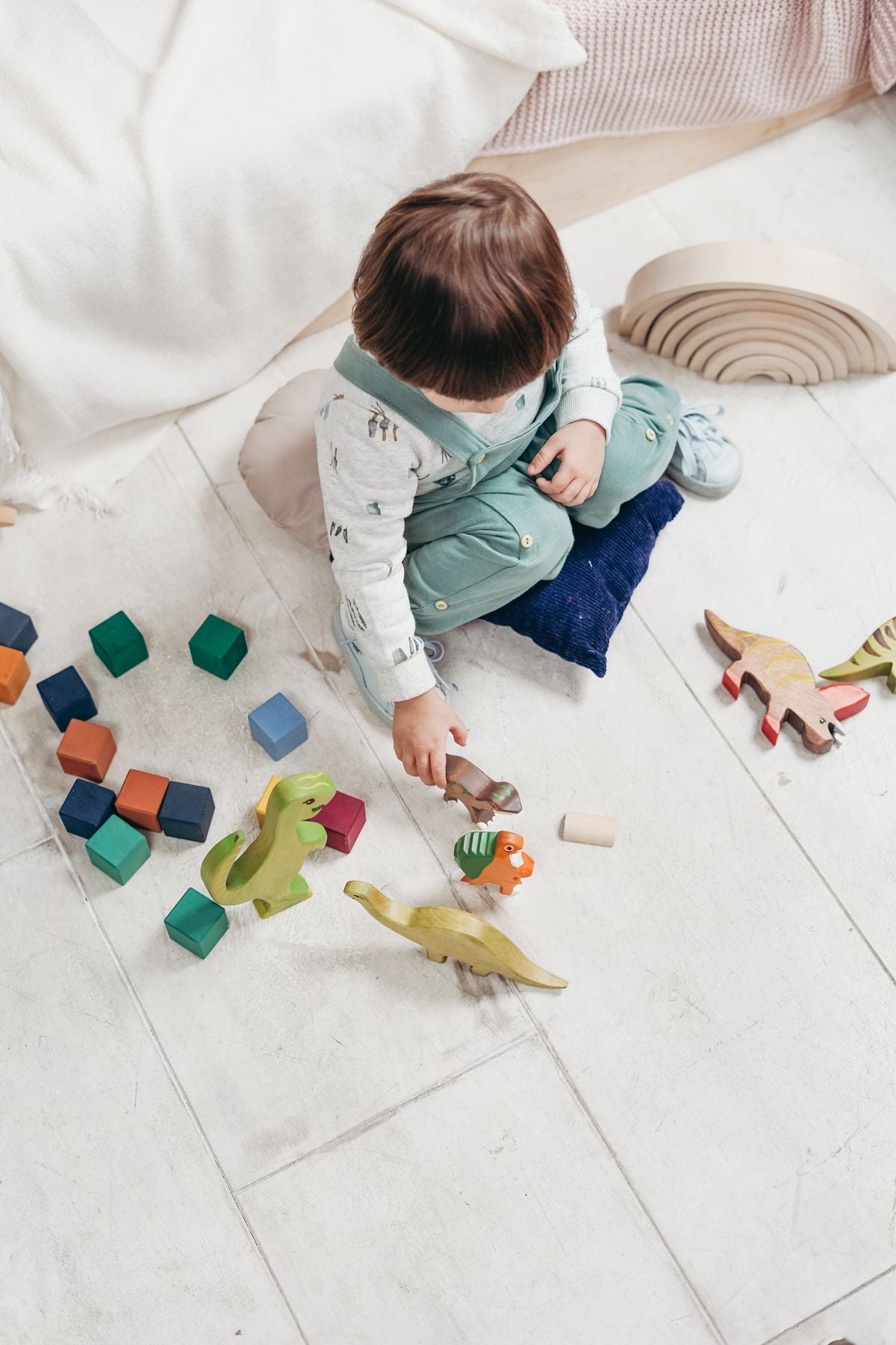 Child playing with colorful building blocks on the floor