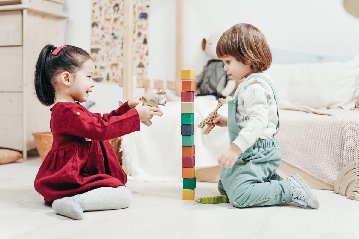 Children playing on a soft rug on the floor