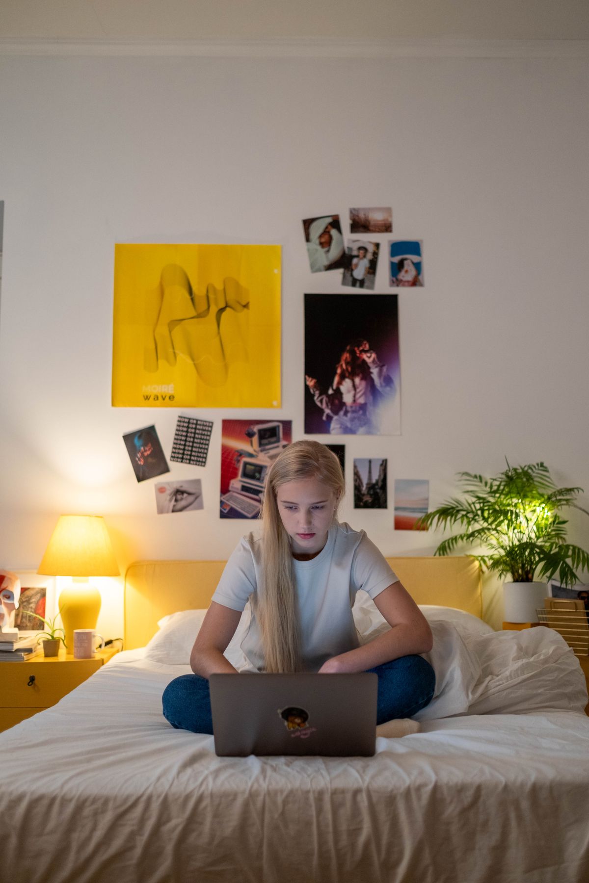Tween relaxing with a laptop in their bedroom