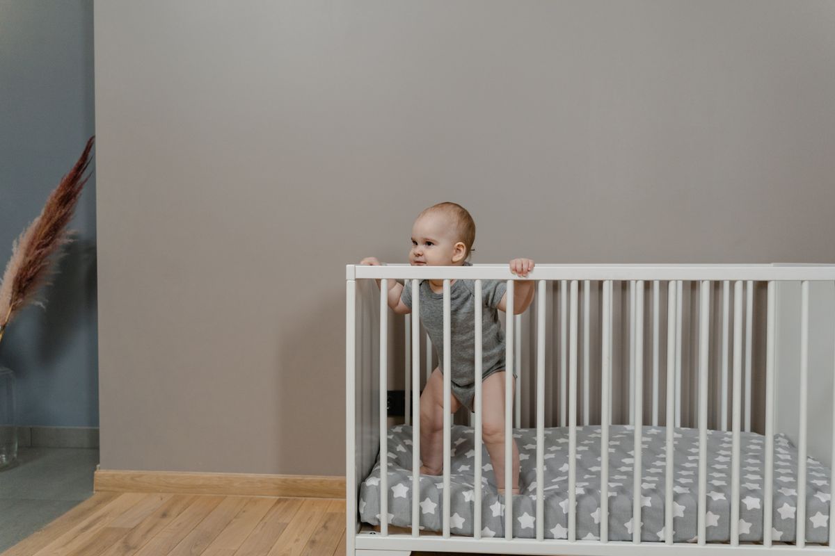 Toddler standing in a crib, growing fast