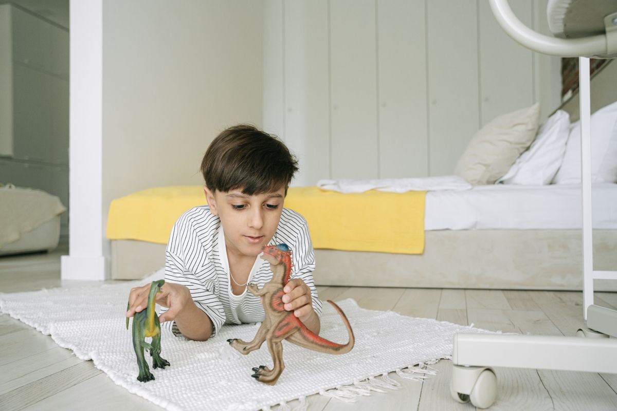Child playing with dinosaur and animal toys