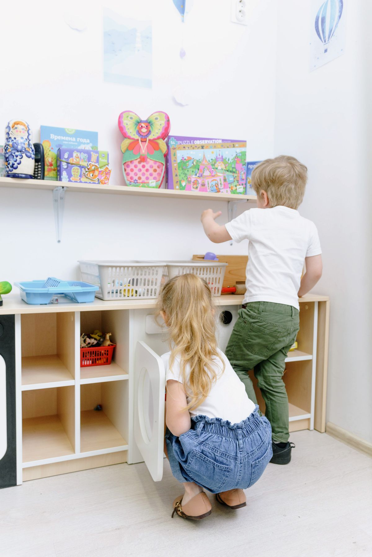 Children tidying up their room together